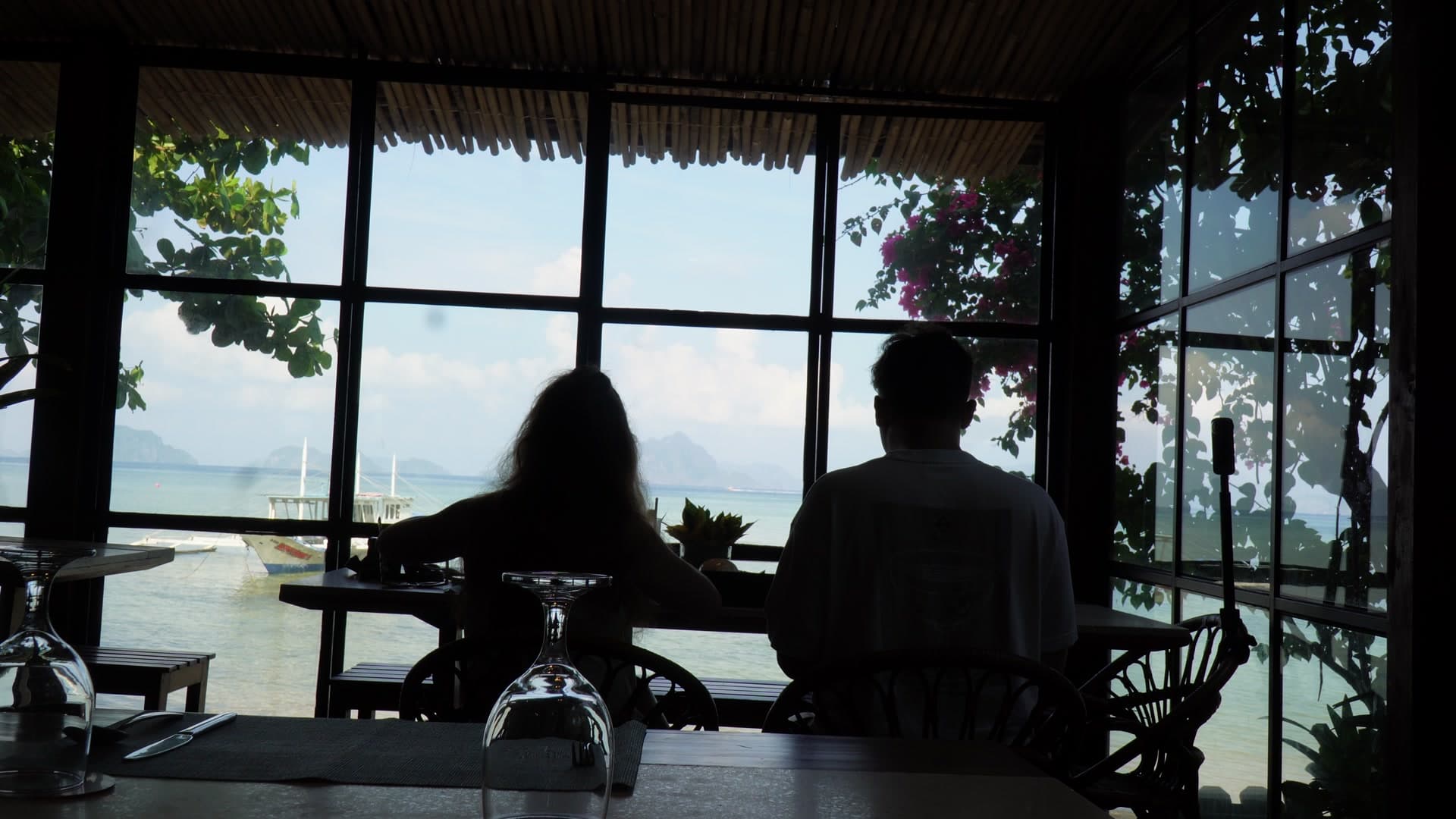 Travellers watching the ocean from a cliffside villa